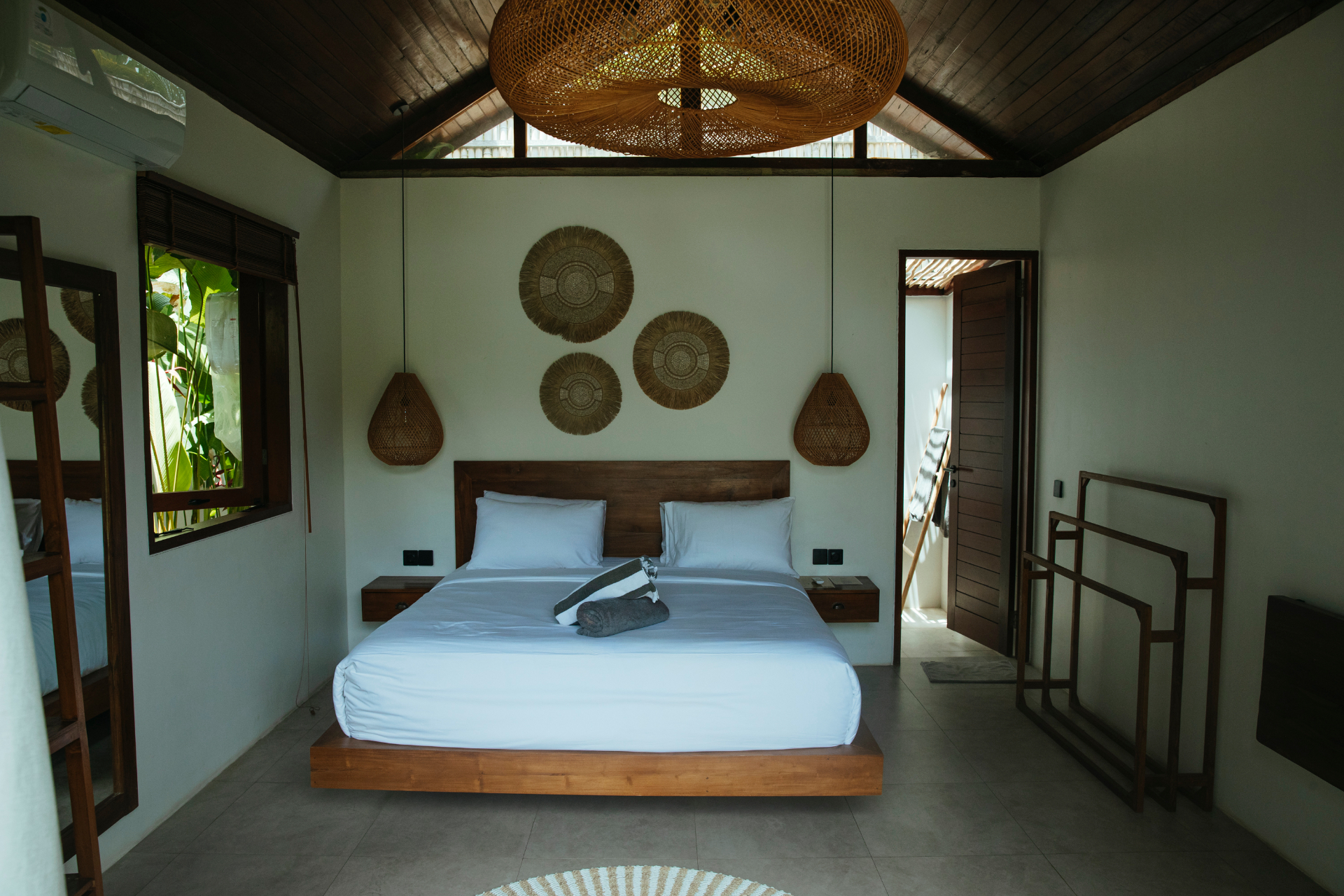 Bedroom interior with king bed and rattan pendants