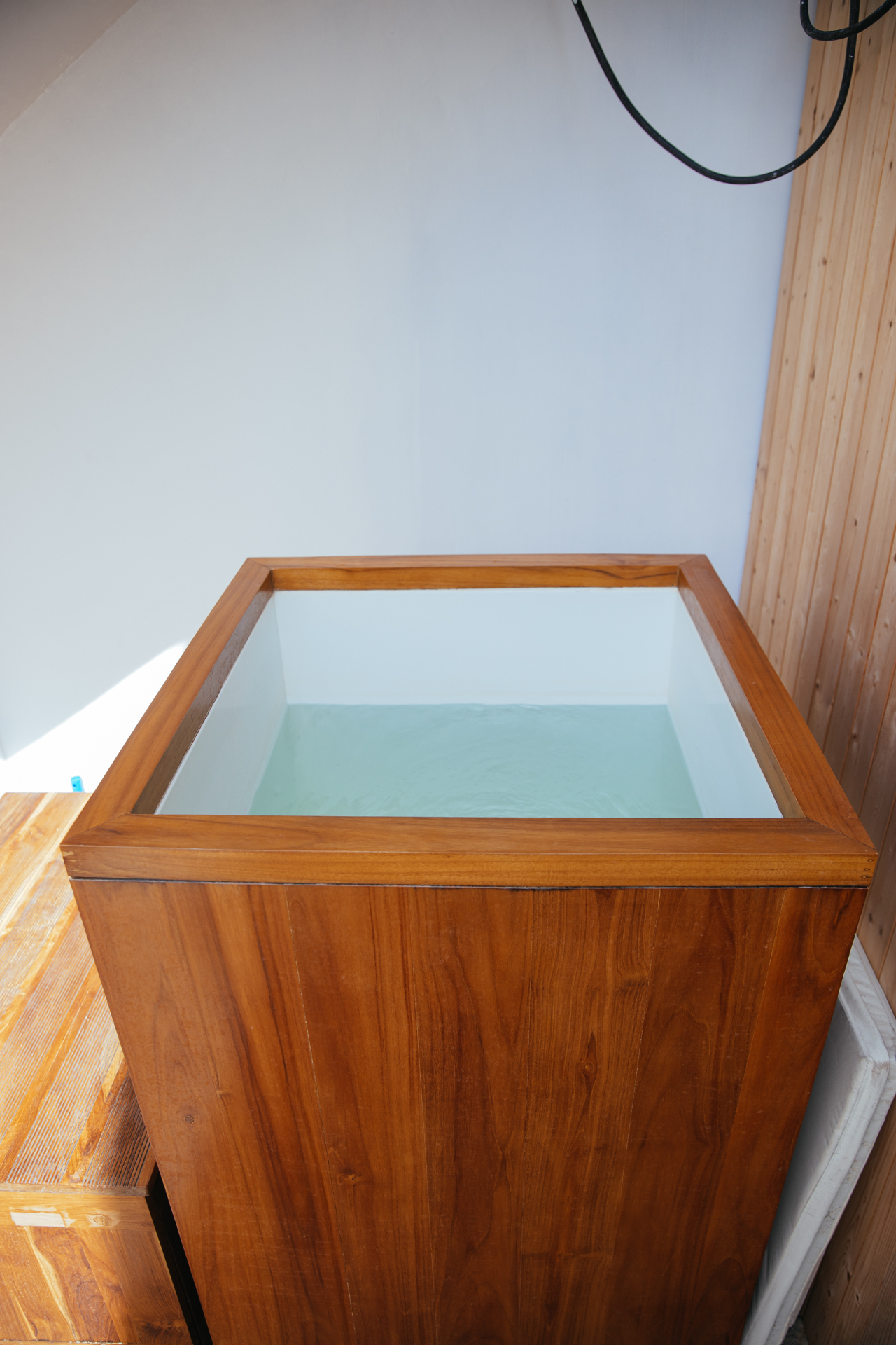Teak ice bath filled with cold water